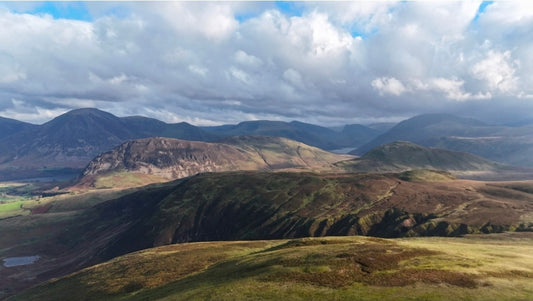 Panoramic view of the Western Fells from Blake Fell with sunlight across the ridges