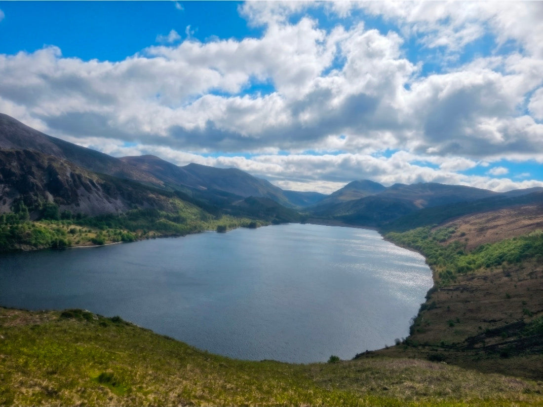 Looking along Ennerdale Water towards the western Lake District fells under a blue sky and clouds