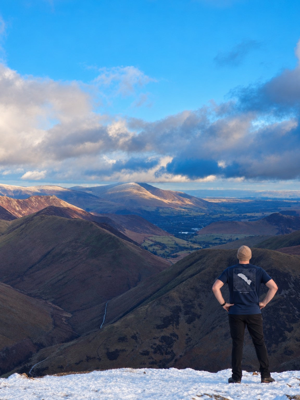 Person wearing the Blake Fell Buttermere contour T-shirt overlooking the Lake District fells in winter